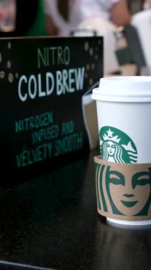 Vancouver 'da, Kanada' da Starbucks çeşitli içeceklerden oluşan bir kahve hazırlıyor. Beyaz t-shirt önlüklü ve maskeli kadınlar BC Vancouver 2023