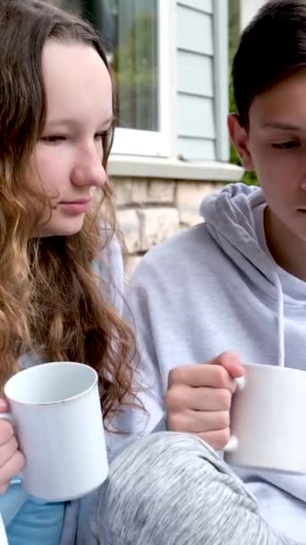 Spiele Telefon Tee Trinken Auf Der Veranda Jungen Und Mädchen — Stockvideo