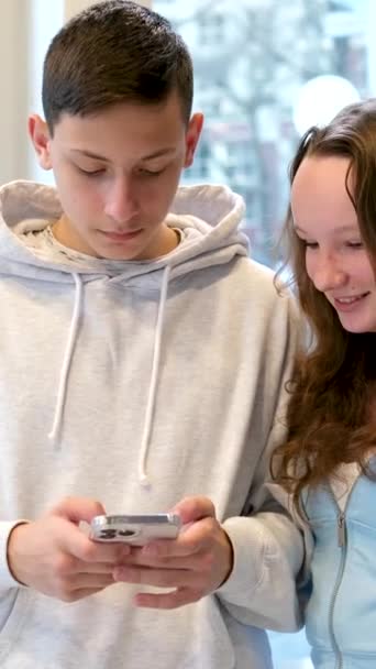Tonåringars Liv Telefon Pojke Och Flicka Sitter Vid Ett Bord — Stockvideo