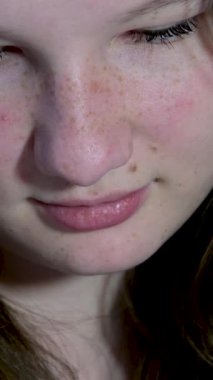 Kız saçlarını eğdi ve telefonda bir şeyler okudu ya da genç bir kadının yakın çekimdeki bir kitabında yatak odasının arka planına ve evde yalnız başına geçirmesi için yapay lamba gecesine karşı.