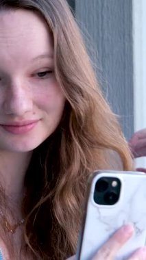 Genç bir kadın video çağrı video blogcusu ile konuşuyor. Akıllı telefon kullanarak kameranın internet kamerasından konuşuyor. Selfie ile yapılan telefon görüşmeleri yaşam tarzı vlog 'u, blogcu çevrimiçi yayınları, arkadaşlarıyla iletişim kuruyor.