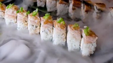 Lezzetli bir restoranda Asya yemeği suşisi tabağında kuru buz dekorasyonu restoranı taştan tabakta lezzetli ton balığı seti ve uzay metni reklamının her yerinde akan beyaz dumanla servis ediliyor.