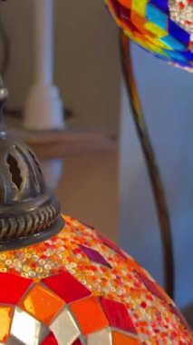 Mağazada çok renkli parlak Türk lambaları farklı renklerde parlıyor. Mozaik renkli yıldızlar ve lambaların üzerine boyanmış çiçekler.