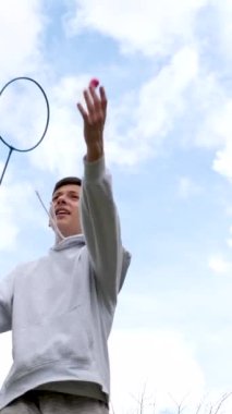 Genç bir adam badminton 'da raket ve mekikle oynuyor. Ağır çekim. Yüksek kalite 4k görüntü