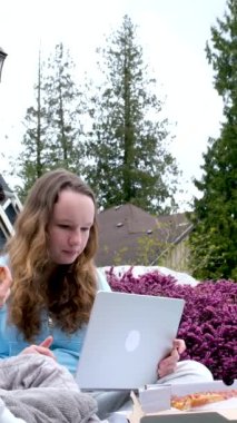 Çevrimiçi öğrenim erkek açık havada kız çocuk piknik yapıyor pizza yiyor ev ödevi yapıyor dizüstü bilgisayarla iletişim sorunu yaşıyor ciddi yüzleri çözüyor 