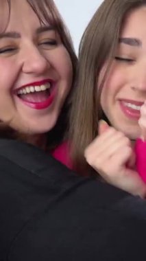 Anne ve kızının güzel bir ailesi var, evde sarılıp öpüşüyorlar. Büyük anne ve yetişkin kızı kucaklaşıyorlar, kameraya bakıp gülümsüyorlar anne ve kız meme için kayıt yaptırıyorlar.