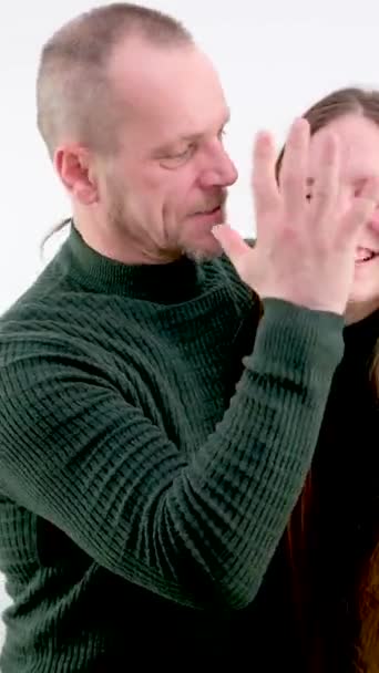 男人用白色的背景捂住女友的嘴 家庭暴力的近照男性拳头 愤怒的男人和害怕的女人在背后 她双手合上了脸 在家里 — 图库视频影像
