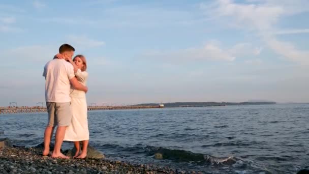 夫女性カップル愛結婚若いです大人抱擁距離海の空の石の美しさ愛ロマンス — ストック動画