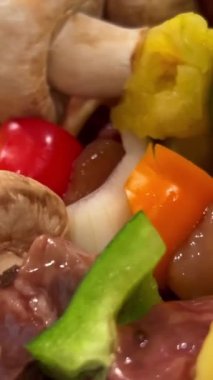 Bir sürü sebzeli, tavuk ve domuz kızartmalı leziz kebap ızgarada ızgarayı çevir ve sosa bulaştır. 