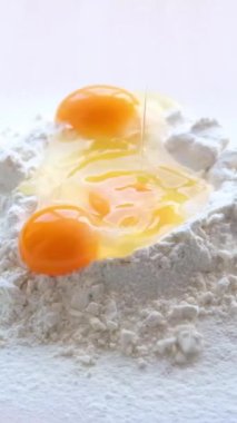 Egg Falling on Flour, Slow Motion 4K. bad shot for a cooking show of egg-flourising wheat flour egg white and egg yolk in one shot eggs fall on the flour and spill around the idea High quality FullHD