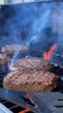 barbecue for a hamburger cooked on an open fire and turned over meat patties ground minced meat ready fried and very tasty turn over with a spatula on fire. the fire just burns and is very tasty.