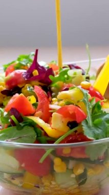Sağlıklı sebze salatasının içine salata sosu döküyorum. Salata sosu. Yüksek kalite 4k görüntü