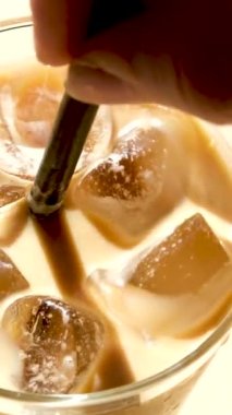 Buzlu Dalgona kahvesi ve ahşap tepside kremalı hazır kahve. Mermer kahverengi masada trend Kore içkisi lattesi. Yüksek kalite 4k görüntü