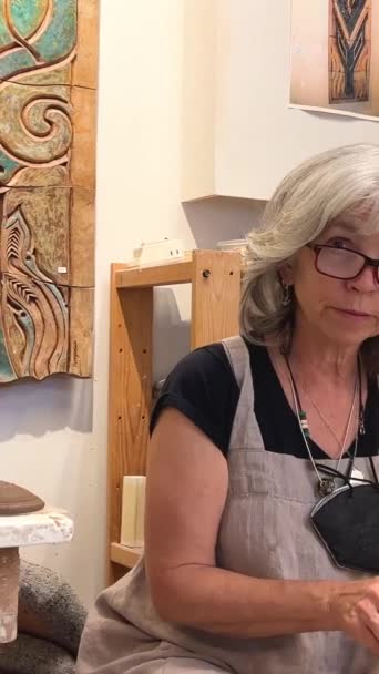 一个女人在陶瓷轮上做乳酪 她用黏土旁边的蛇纹石把多余的东西削平 — 图库视频影像