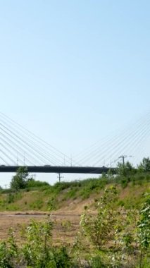 BC 'nin alt tarafındaki Fraser Nehri üzerindeki iskele köprüsü Kanada. Yakından bakınca büyük beyaz gerilmiş kablolar büyük bir köprü tutuyor. Coquitlam Limanı, Büyük Vancouver, British Columbia, Kanada 2023