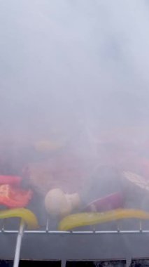 Kalın beyaz duman şiş kebap parçalarını şiş şiş bağlayıp profesyonel bir ızgarada pişirmekten geliyor. Sıcak kömürden kızartılmış et. Ermeni khorovatları. Yüksek kalite 4k görüntü