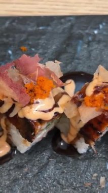 Black DRAGON ROLL Yengeç Eti, Avokado, Kappa Unagi, Avokado, Balık Gevreği ve Çiçekle süslenmiş Balık Restoranı