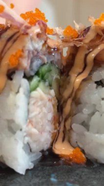 Black DRAGON ROLL Yengeç Eti, Avokado, Kappa Unagi, Avokado, Balık Gevreği ve Çiçekle süslenmiş Balık Restoranı