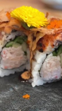 Black DRAGON ROLL Yengeç Eti, Avokado, Kappa Unagi, Avokado, Balık Gevreği ve Çiçekle süslenmiş Balık Restoranı