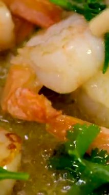 Karidesler yağlı ve kızarmış soğanlı kızartma tavasına konur ve doğuya özgü çubuklarla karıştırılır. Yüksek kalite 4k görüntü