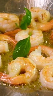 Yavaş çekim videosu çok güzel yemek karidesleri yağda kaynatıyor tavada fesleğen serpiştiriyor Wok yağ serpiştiriyor yakın doğu deniz ürünleri restoranı