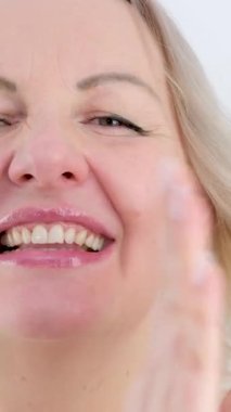 dikey video. Ellerinizi çırpın ya da el çırpın beyaz tenli arka planda yaşayan 30-50 yaşlarında genç bir kadın. Alkışlar, gülüşler, samimi gülümsemeler omuzlarınızı silkeleyin. 