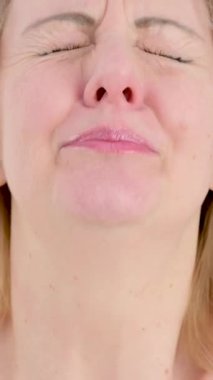 Hasta, yaşlı, gri saçlı, 50 'li yaşlarda, beyaz gömlekli, hapşırık bir kadın. Açık mavi arka plan stüdyo resminde izole edilmiş. Sağlıklı yaşam tarzı hastalıklı hastalık tedavi konsepti.