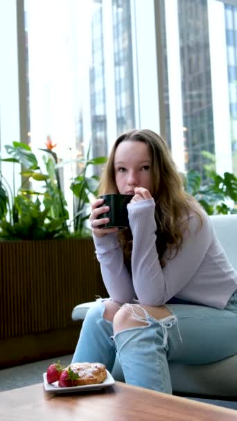 Meisje Drinkt Koffie Met Plezier Uit Een Zwarte Beker Zit — Stockvideo