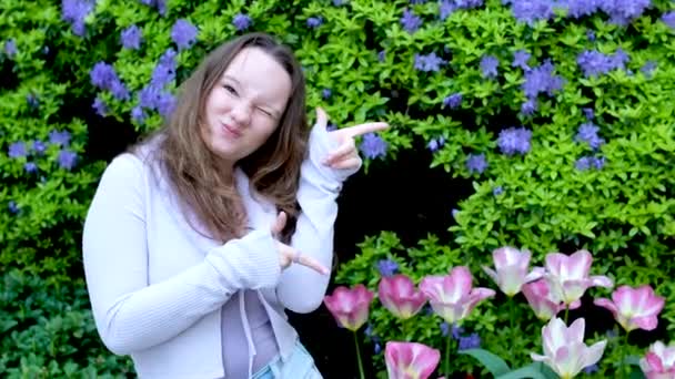 Молодая Девушка Счастливо Указывает Пальцами Вверх Сторону Рекламу Парке Морщины — стоковое видео