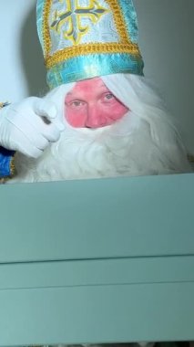Sinterklaas portresi. Beyaz arka planda ABD. Hollandalı Noel Baba Aziz Nicholas yeni yıl hediyesi olarak büyük mavi bir kulübe açtı. Kutu boş. Yeni yıl yaklaşıyor.