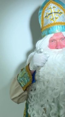 Noel Baba turkuaz takım elbisesinin kurucusu Aziz Nicholas 'ın farklı pozitif duyguları vardı. Geleneksel bir dini şapkayla, tıpkı bir papazın cübbesi ve kemeri olması gibi.