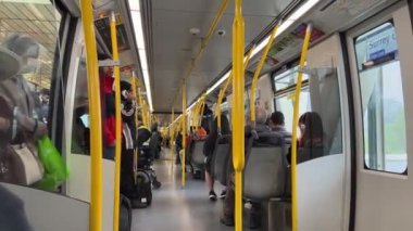 Toplu taşımacılık farklı milletlerden Gökyüzü Treni insanları trene biniyor ve yaşlı bir kadına yol veriyor. Kanada Vancouver 07.07.2023 engelliler ve yaşlılar için koltuk.