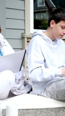 Hoş bir ilişki. Ergenler erkek ve kız verandada dizüstü bilgisayarla ders yapıyorlar. Dışarıda oturup gülen sevimli çocuklar. İnsanlar sevinç, şefkat ve iletişim çantası gösteriyor.