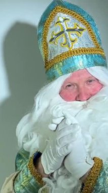 Noel Baba turkuaz takım elbisesinin kurucusu Aziz Nicholas 'ın farklı pozitif duyguları vardı. Geleneksel bir dini şapkayla, tıpkı bir papazın cübbesi ve kemeri olması gibi.