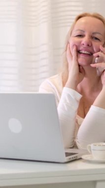 Sarışın kadın telefonda konuşuyor ve gülümsüyor. Yüksek kalite 4k görüntü