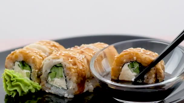 Dunk Een Sushi Rol Sojasaus Zwarte Achtergrond Een Close Hoge — Stockvideo