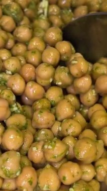Beyaz bir tabakta kaynamış nohut. Kaşıkla toplanıp humus pişiriliyor. Sağlıklı yemek sincapları.