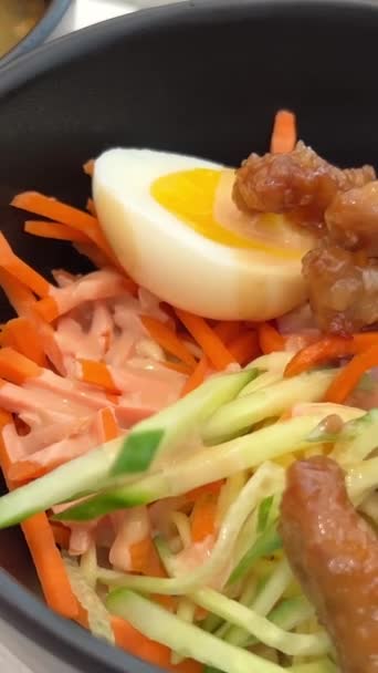 台湾風冷乾麺半熟卵台湾料理アジア料理黒皿 箸で野菜の下から春雨を茹でるキュウリニンジンをジュリエンヌの健康に切る — ストック動画
