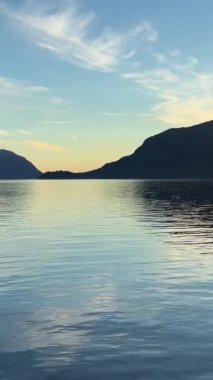 Seyahat acentesi Porteau Cove Provincial Park Sunset City 'nin arka planı Pasifik Okyanusu' nda yansıyan suya daldı ve ayna görüntüsü yarattı. 