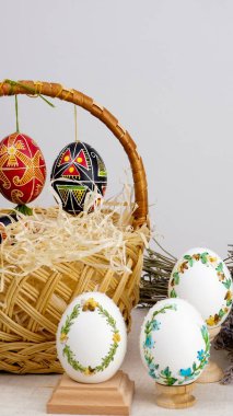 Paskalya kompozisyonu telefon ile beyaz krom anahtar ekranlı yumurta sepeti ve lavanta rengi yumurta boyalı lavanta çiçekleri ahşap bardak altlıkları Paskalya arka planında 