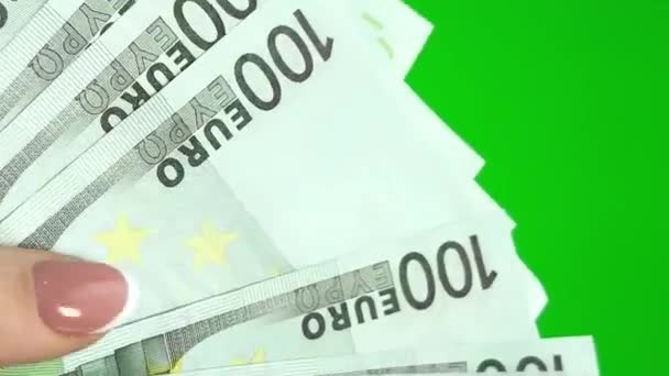 女性の手の中の緑の背景のクロマキーの100ユーロの紙幣はお金を数える現金机の通貨交換販売の富 — ストック動画