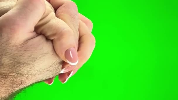 緑の背景に男と女の二人の手クロマキーは 交差指を滑らかに会い 喜びを満たすという彼らの愛の概念を絞る — ストック動画