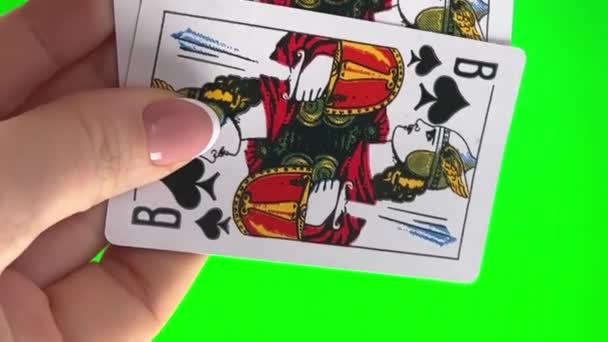 フランスのマニキュアで緑の背景クローズアップ女性の手に4枚のカードを保持手 女性はカードを並べ替え 折り目を調べ 同じスートのジャックカードの左のファン4枚のカードのように広がる — ストック動画