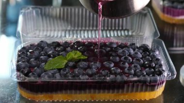 Evde meyveli jöleli kek pişirmek. Karıştırıcıda lezzetli tatlı ritmi katmanları dökmek. Plastik bir kapta yemek kaşığıyla pürüzsüz. Lezzetli bir tatlı. Yabanmersinli krema dök.