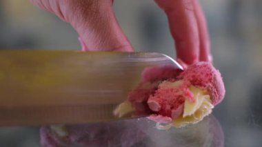 Kadın eli ve cam masaya yakın duran bir bıçak Fransız tatlısını bir sürü gözenekli fırın yapısı ile kesiyor. Badem hamurunun yapısını kontrol eden lezzetli taze badem kurabiyeleri.