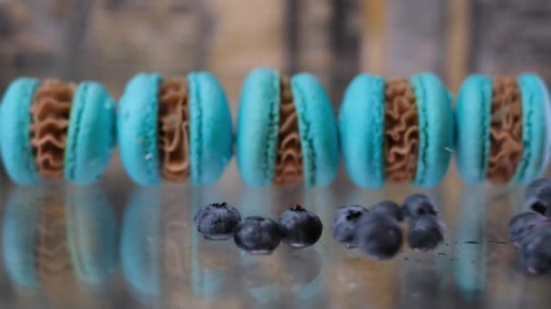 Myrtilles Rouler Sur Une Table Verre Sur Fond Bleu Macarons — Video