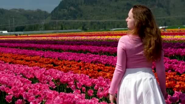 Chica Vestido Blanco Sentado Entre Las Flores Cerca Los Tulipanes — Vídeos de Stock