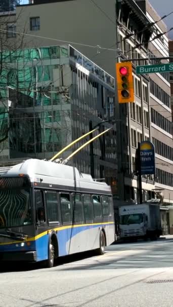 バーバード駅のオフィスビル街トロリーバスのタクシーの信号機で働くために急いで人々 男性と女性が交差する通りは公共交通機関の都市生活に入るカナダバンクーバー12 2023 — ストック動画