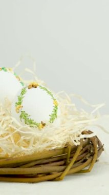 easter holiday banner side view of eggs in nest lavender flowers ribbon embroidery on eggshell white eggs lie on straw on right space for text advertising ads postcard billboard easter holiday
