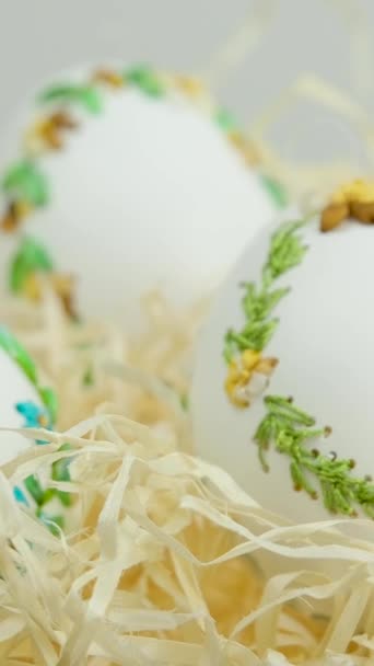 イースター3美しい刺繍卵とともに卵シェルリボンで巣内包装紙白背景スペースのためのテキストお祝いの会議家族の装飾家の装飾ギフト配達 — ストック動画